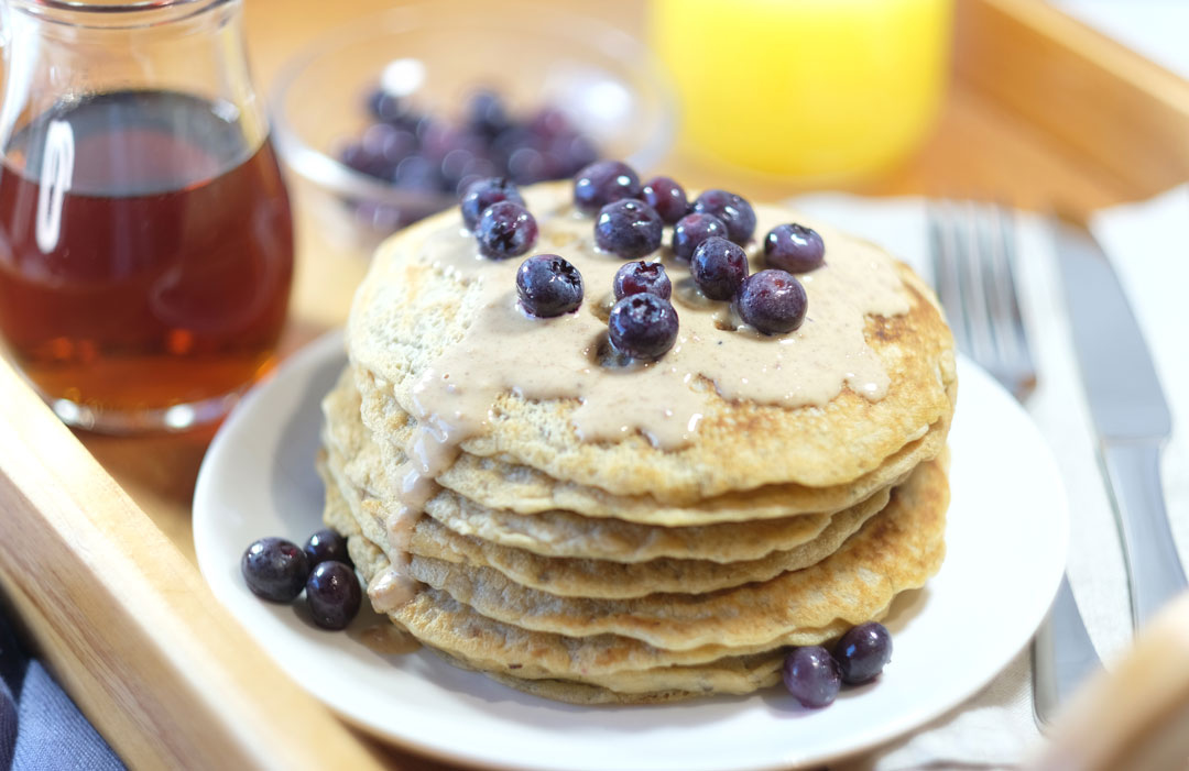 vegan-pancakes vegan pancakes on a breakfast tray with maple syrup and orange juice