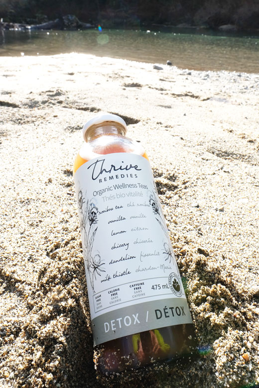 detox-tea bottle of detox in the sand at a lake