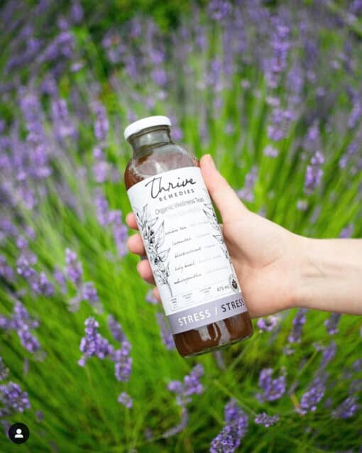 woman's hand holding a bottle of stress over a field of lavender