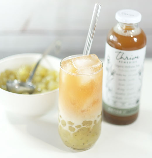 healthy-bubble-tea detox bubble tea next to a bottle of thrive and a bowl of kiwi tapioca pearls