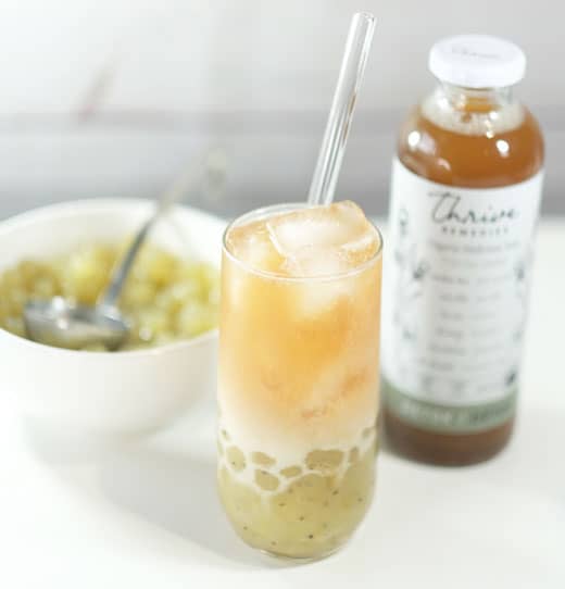 healthy-bubble-tea detox bubble tea next to a bottle of thrive and a bowl of kiwi tapioca pearls