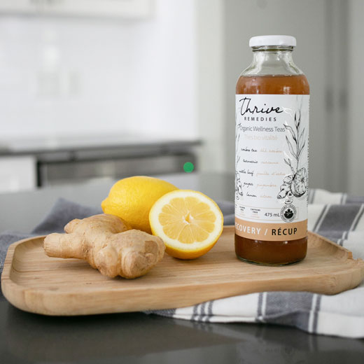 turmeric-tea-square bottle of recovery turmeric tea next to lemons and ginger