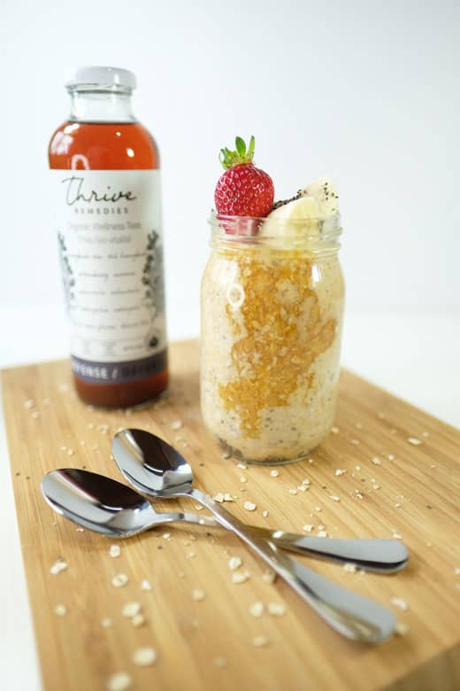 overnight oats on a wooden cutting board next to a bottle of defense