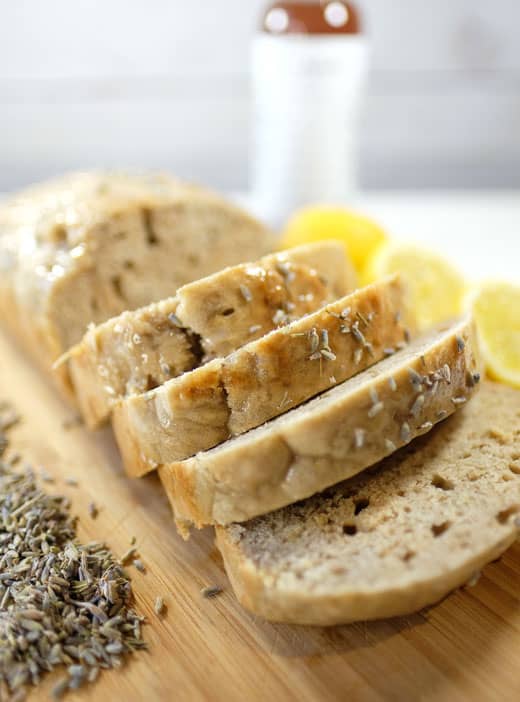 vegan-lavender-lemon-loaf vegan lemon loaf on a cutting board next to some lemons
